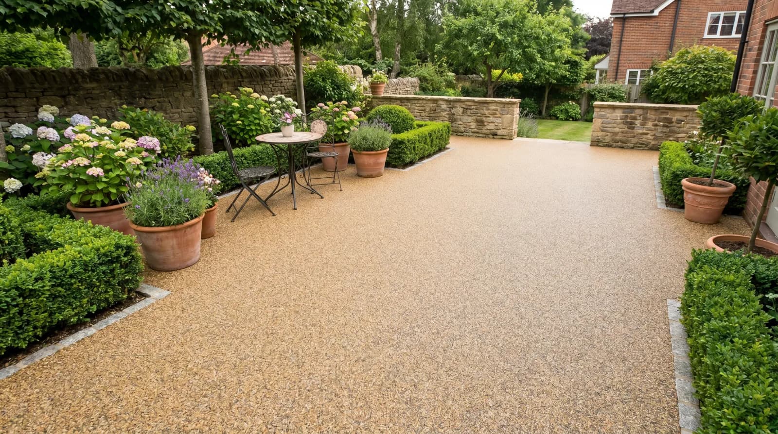 Illustrated larger buff patio with planting and a seating area at one side